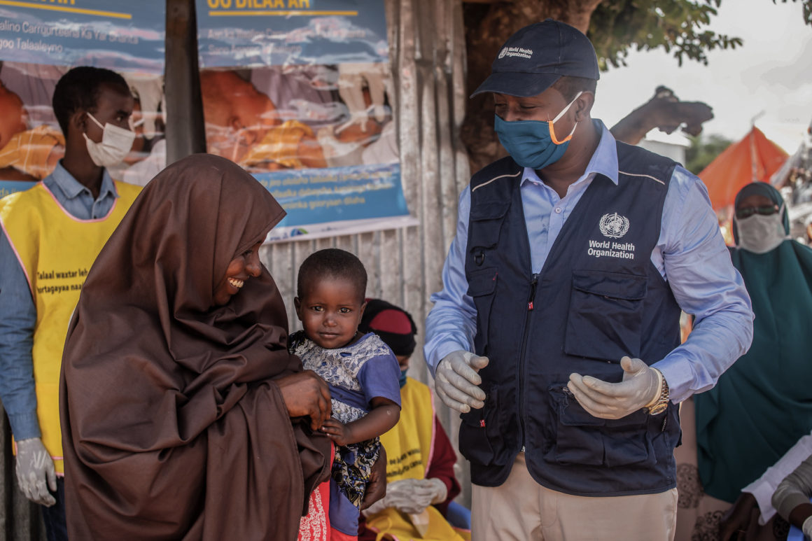 A staff of the World Health Organization (WHO) talks to a mother during an immunization exercise in Kahda district of Mogadishu, Somalia on September 1, 2020