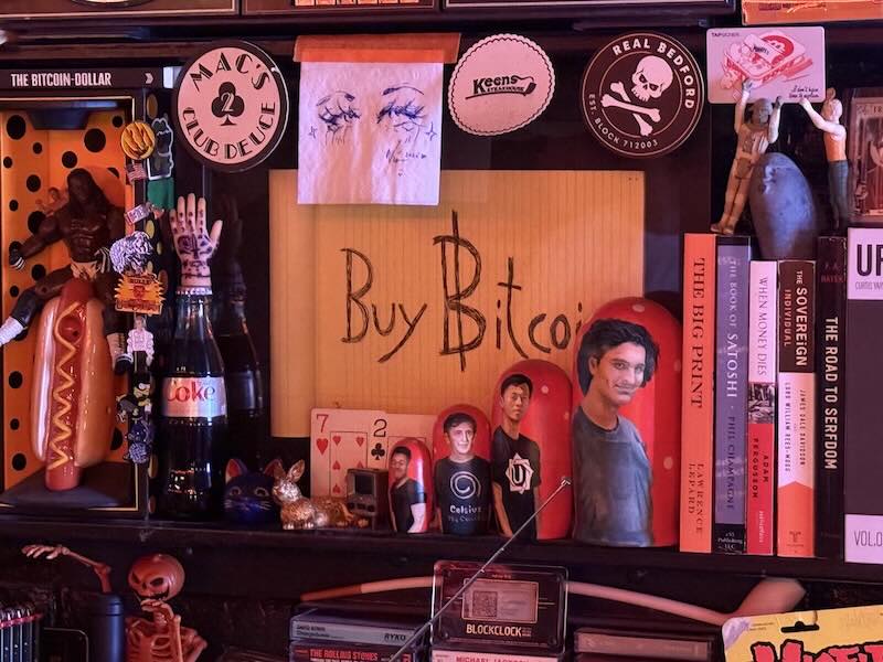 Bitcoin display at PubKey bar with books and art