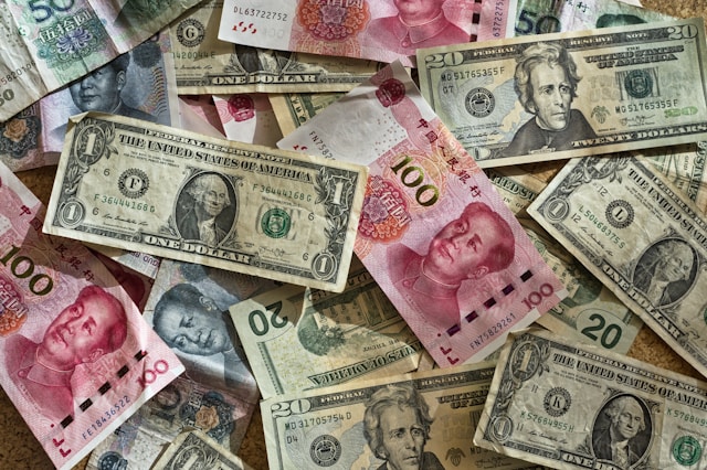 US dollar bills and Chinese RMB bills laid out on a flat surface